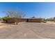 Tan single-story home with a spacious driveway and tree in the front yard at 7102 E Larkspur Dr, Scottsdale, AZ 85254