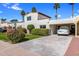 Charming home featuring a red tile roof, lush landscaping, and a covered parking area at 7644 E Mariposa Dr, Scottsdale, AZ 85251