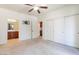 Spacious bedroom with carpet, ceiling fan, closet, and bathroom access at 7726 E Baseline Rd # 110, Mesa, AZ 85209