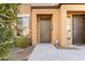 Home's front entrance showcasing a well-lit porch, secure door, and manicured landscaping at 7726 E Baseline Rd # 110, Mesa, AZ 85209