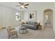 Bright living room featuring neutral tones, modern furnishings, ceiling fan, and natural light from a large window at 7726 E Baseline Rd # 110, Mesa, AZ 85209