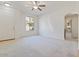 Bright living room features neutral carpet, ceiling fan, and arched doorway at 7726 E Baseline Rd # 110, Mesa, AZ 85209