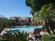 Community pool with lounge chairs surrounded by lush landscaping and palm trees at 7950 E Starlight Way # 128, Scottsdale, AZ 85250