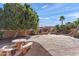 Landscaped backyard featuring a concrete patio, stone table, and basketball court at 8421 W Alex Ave, Peoria, AZ 85382