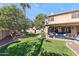 Lush backyard featuring a covered patio, swing, and vibrant green lawn at 8421 W Alex Ave, Peoria, AZ 85382