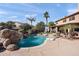 Expansive backyard with pool, waterfall, and lush landscaping, perfect for outdoor enjoyment and activities at 8421 W Alex Ave, Peoria, AZ 85382