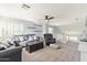 Bright living room with gray sofa, area rug, ceiling fan, and window with custom shutters at 8421 W Alex Ave, Peoria, AZ 85382