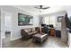 Well-lit home office with wood-look floors, a ceiling fan, and a comfortable sitting area with a leather couch at 8421 W Alex Ave, Peoria, AZ 85382