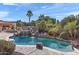 Sparkling pool with rock waterfall feature, slide, and lush tropical landscaping creating a backyard oasis at 8421 W Alex Ave, Peoria, AZ 85382