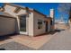 Home's outdoor space featuring a textured stucco finish, updated windows, and a concrete paver patio at 8772 W Grovers W Ave, Peoria, AZ 85382