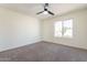 Bright bedroom featuring ceiling fan, window and neutral carpet at 8772 W Grovers W Ave, Peoria, AZ 85382