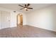 A bright bedroom with wood floors, ceiling fan, and closet with mirrored doors at 8772 W Grovers W Ave, Peoria, AZ 85382