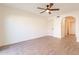 A bedroom with wood floors, ceiling fan, closet, and view of an adjacent room at 8772 W Grovers W Ave, Peoria, AZ 85382