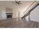 Bright living room featuring a modern fireplace, updated flooring, and a staircase to the second floor at 8772 W Grovers W Ave, Peoria, AZ 85382