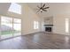 Bright living room featuring a stacked stone fireplace, modern flooring, and a sliding glass door to the backyard at 8772 W Grovers W Ave, Peoria, AZ 85382