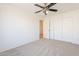 Bright bedroom featuring carpet flooring, ceiling fan, and a closet with sliding doors at 9705 E Butte St, Mesa, AZ 85207