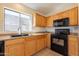 Functional kitchen featuring wooden cabinets, a black oven, and a modern faucet at 9705 E Butte St, Mesa, AZ 85207