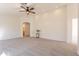 Spacious, light-filled living room with plush carpet, a ceiling fan, and neutral paint at 9705 E Butte St, Mesa, AZ 85207