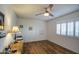 Comfortable bedroom with hardwood floors, a large window, and a classic desk with lamp at 9806 W Long Hills Dr, Sun City, AZ 85351