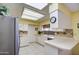 Spacious kitchen with white cabinets, tile floors, and stainless refrigerator at 9806 W Long Hills Dr, Sun City, AZ 85351