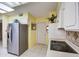 Well lit kitchen with stainless steel refrigerator, and white oven and microwave at 9806 W Long Hills Dr, Sun City, AZ 85351