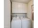 Bright laundry room includes washer, dryer, and overhead cabinets at 9806 W Long Hills Dr, Sun City, AZ 85351