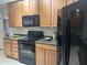 The kitchen features wood cabinets and modern black appliances at 11000 N 77Th Pl # 1072, Scottsdale, AZ 85260