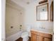 Bright bathroom features a tile-surround tub and shower combination with a wood vanity and framed mirror at 1111 E Village Circle N Dr, Phoenix, AZ 85022