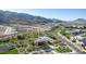 An aerial view of a community pool, clubhouse, and lush landscaping nestled in the mountains at 1115 E Mcneil St, Phoenix, AZ 85042