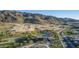 An aerial view of the pool area and the surrounding desert landscape against a mountain backdrop at 1115 E Mcneil St, Phoenix, AZ 85042