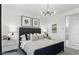 Modern main bedroom featuring a large decorative headboard, modern lighting and neutral decor at 1115 E Mcneil St, Phoenix, AZ 85042