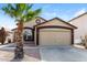 Charming single-story home featuring a two-car garage and desert landscaping with a palm tree at 11609 W Corrine Dr, El Mirage, AZ 85335