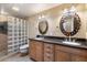 Bathroom featuring double sinks, granite counters, and a walk-in glass block shower at 12530 W Skylark Dr, Sun City West, AZ 85375