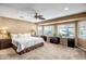 Main bedroom featuring carpeted floors, a ceiling fan, and built-in desks with plenty of natural light at 12530 W Skylark Dr, Sun City West, AZ 85375