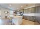 Bright kitchen featuring stainless steel appliances, island with seating, and gray cabinets at 14420 W Faye Way, Surprise, AZ 85387