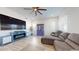 Bright living room featuring a ceiling fan, large windows, and a comfortable grey sectional sofa at 14420 W Faye Way, Surprise, AZ 85387