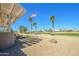 Charming backyard with an American flag, desert landscaping, and a covered patio perfect for relaxing outdoors at 14432 W Robertson Dr, Sun City West, AZ 85375