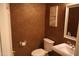 Bathroom featuring tile walls, a toilet, sink, and decorative art at 14432 W Robertson Dr, Sun City West, AZ 85375