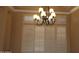 Dining room with detailed crown molding, plantation shutters, and a decorative chandelier at 14432 W Robertson Dr, Sun City West, AZ 85375