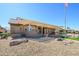 Beautiful home exterior featuring a covered patio, well-maintained landscaping, and a serene backyard setting at 14432 W Robertson Dr, Sun City West, AZ 85375