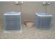 Two outdoor air conditioning units on gravel surface, ensuring efficient climate control for the home at 14432 W Robertson Dr, Sun City West, AZ 85375