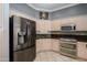 Well-lit kitchen featuring stainless steel appliances, light pink cabinets, and tiled floors at 14432 W Robertson Dr, Sun City West, AZ 85375