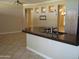 Kitchen island with a sink and a dark countertop is centrally located in an open layout at 14432 W Robertson Dr, Sun City West, AZ 85375