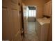 Laundry room featuring tile floors, a utility sink, and plenty of storage at 14432 W Robertson Dr, Sun City West, AZ 85375