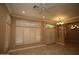 Spacious living area showcasing tile flooring, large windows with custom shutters, and decorative lighting at 14432 W Robertson Dr, Sun City West, AZ 85375