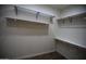 This walk-in closet has wood-look floors, wire shelves and hanging rods at 14432 W Robertson Dr, Sun City West, AZ 85375