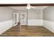 Bright living room with wood-look floors, wainscoting, a ceiling fan, and a glass door at 14645 S 25Th Pl, Phoenix, AZ 85048