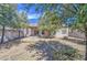 Backyard featuring desert landscaping, trees and a covered patio with sliding glass door at 1541 W Crape Rd, San Tan Valley, AZ 85140