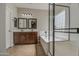 Bathroom featuring a dual sink vanity, soaking tub and shower with a glass block window for natural light at 1541 W Crape Rd, San Tan Valley, AZ 85140