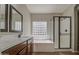 Bathroom featuring a dual sink vanity, soaking tub and shower with a glass block window for natural light at 1541 W Crape Rd, San Tan Valley, AZ 85140